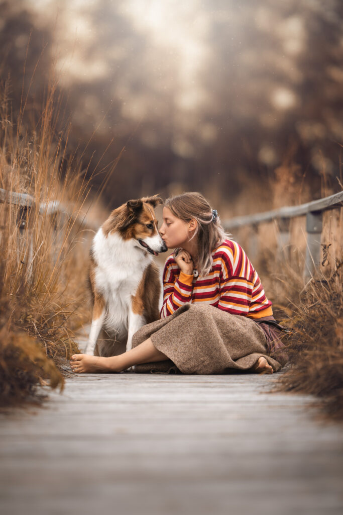 Ein Tiershooting fängt sie ein: Junge Frau, Collie, sanfter Moment draußen.