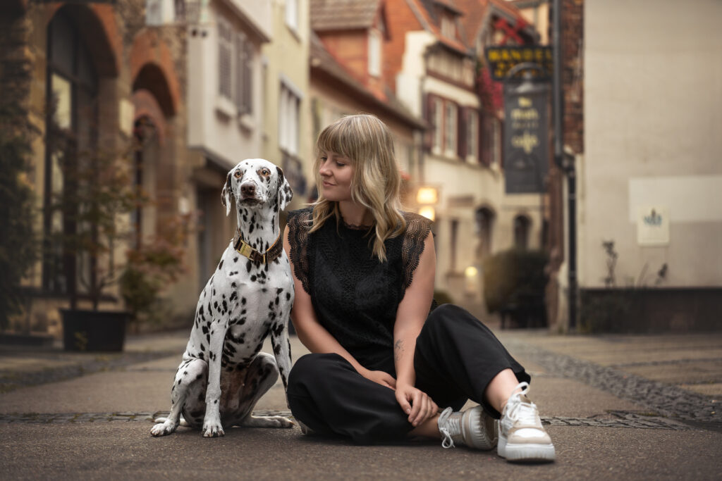Tiershooting auf Kopfsteinpflaster: blonde Frau mit Dalmatiner, Tierfotograf urban dabei.