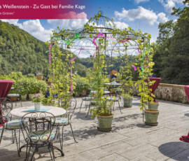 Perfektes Tiershooting: Terrasse mit Rundtischen, Pavillon und grüner Hügelkulisse.